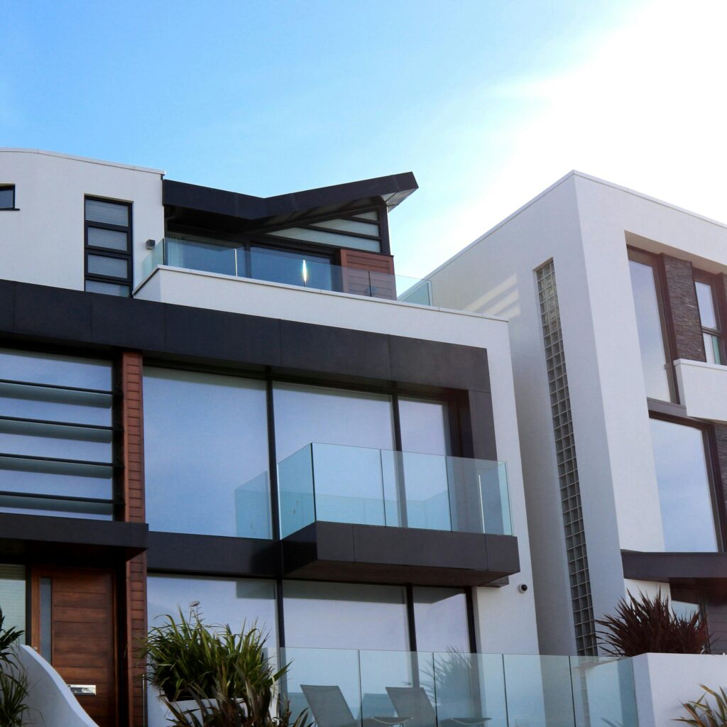 Modern white and black building with large windows and glass balconies