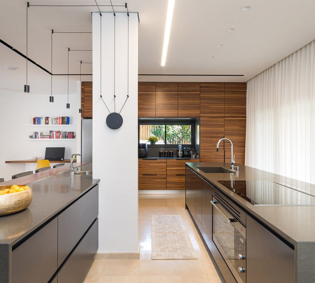 Modern kitchen with two islands, wood cabinets, and living room view