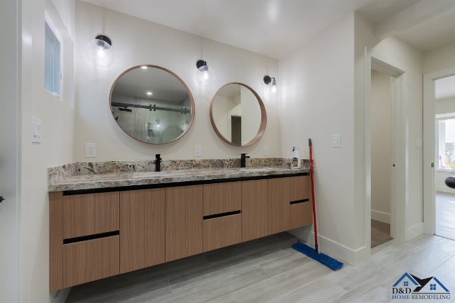 Double vanity with round mirrors and modern light fixtures in a bathroom.