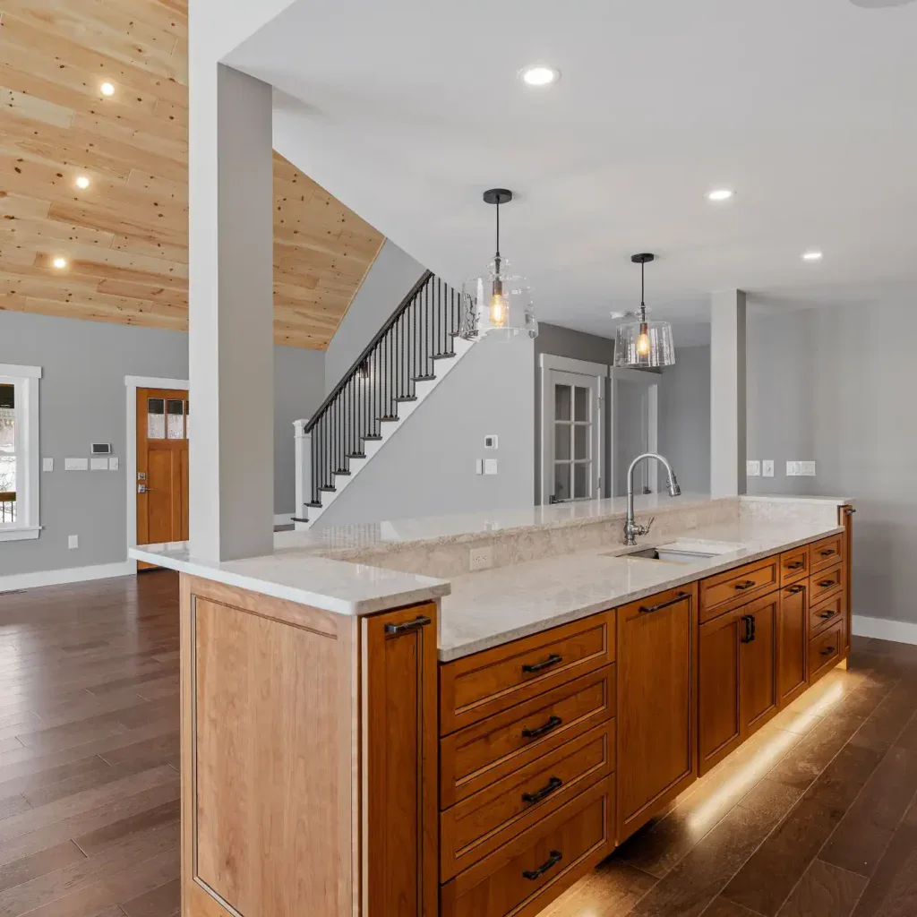 Modern kitchen island with wood cabinets and marble countertop in a new home.
