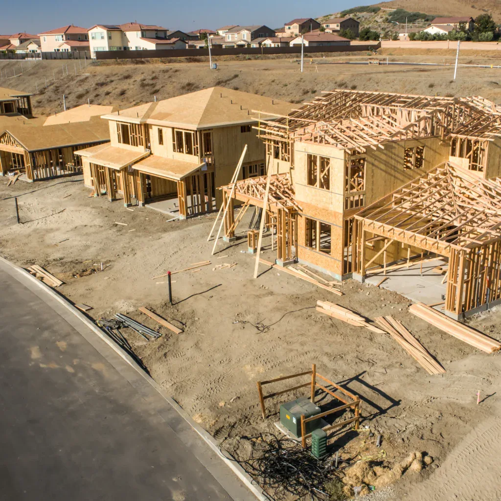 Aerial view of new homes under construction with wood framing and roofs