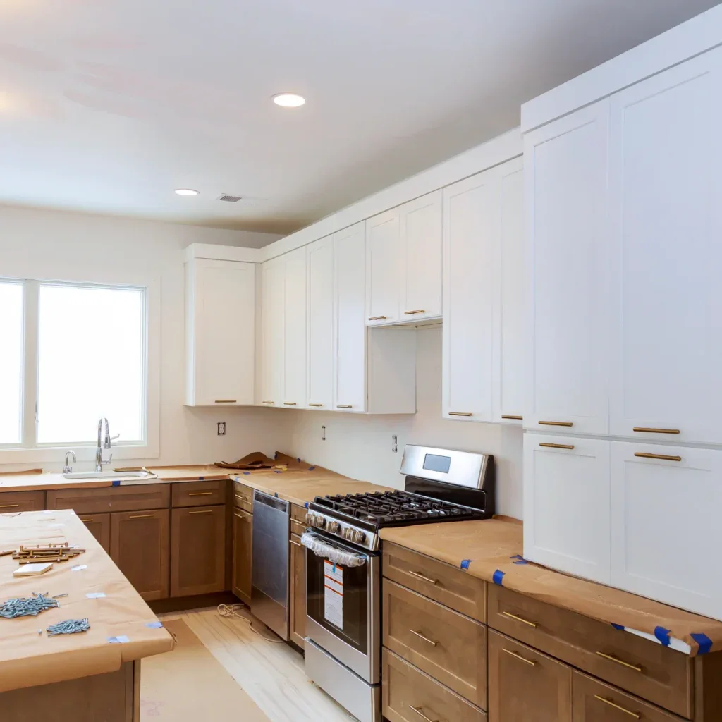 Unfinished kitchen with white upper cabinets and brown lower cabinets